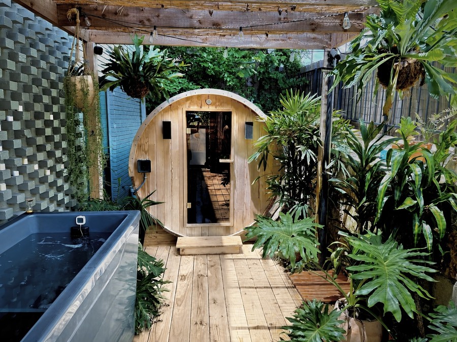 The communal garden at Cøntrast — traditional wood sauna, two cold plunges and an outdoor shower