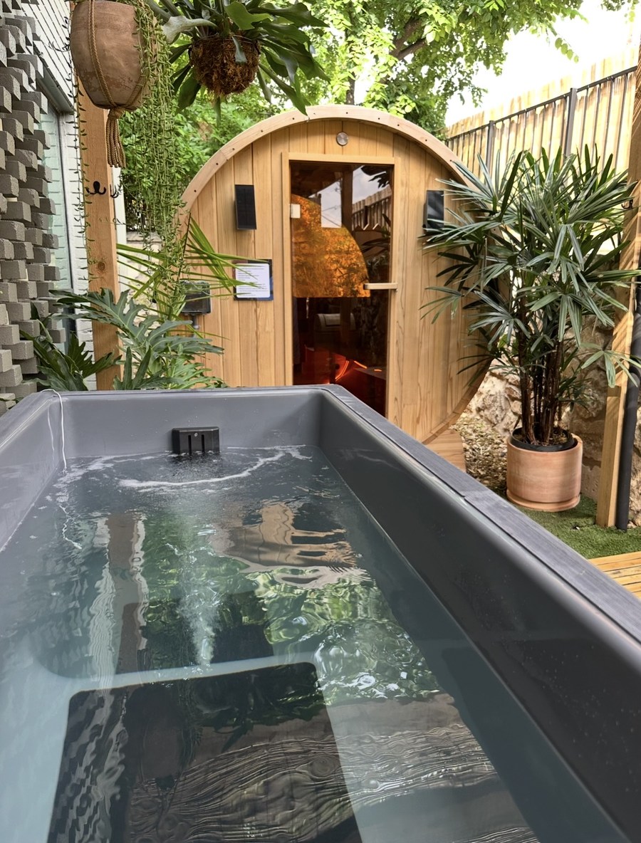 A cold plunge in the Garden with the barrel sauna behind it